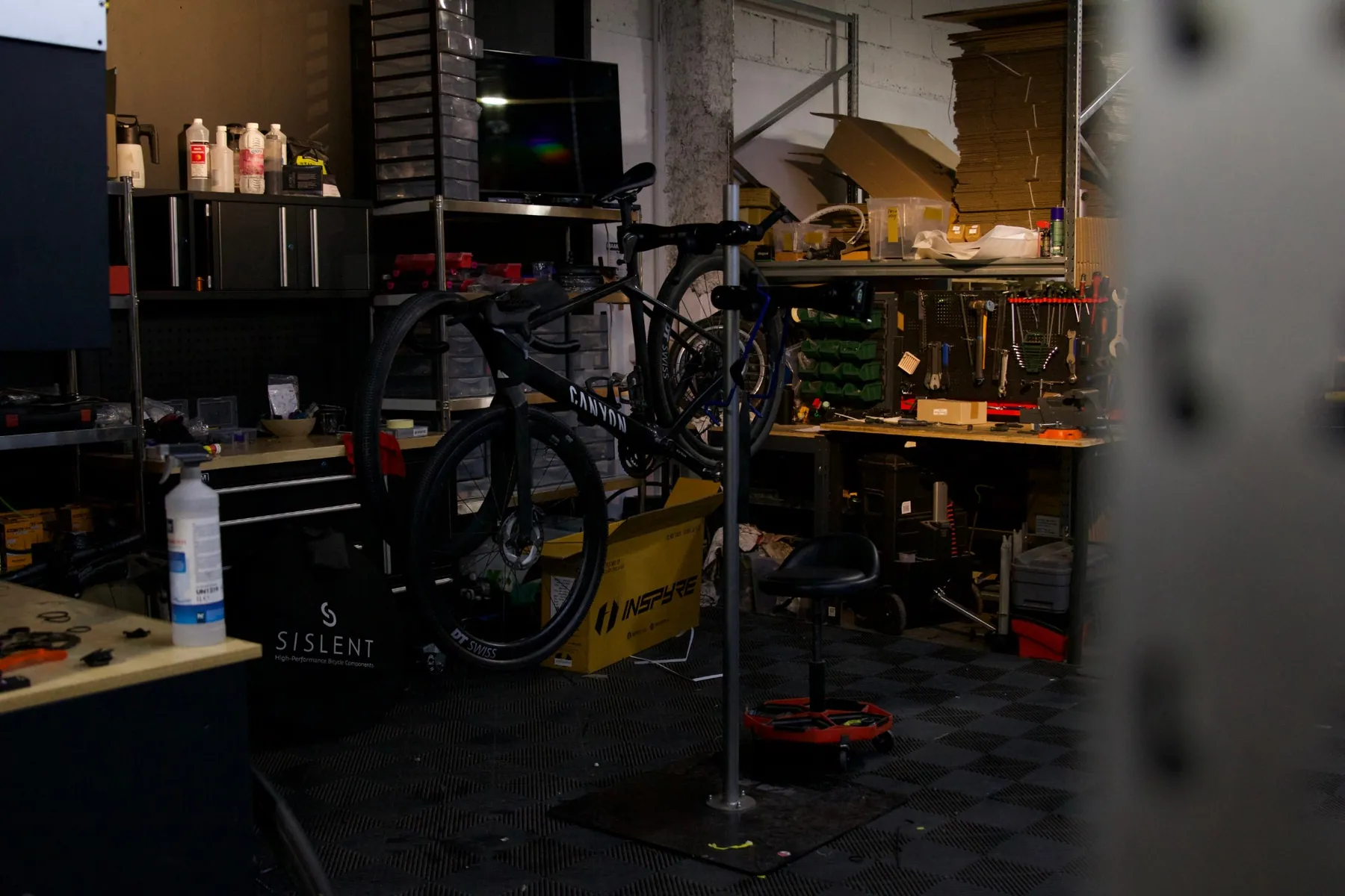 The workshop: a bike on the repair stand, the bench and the tool wall.